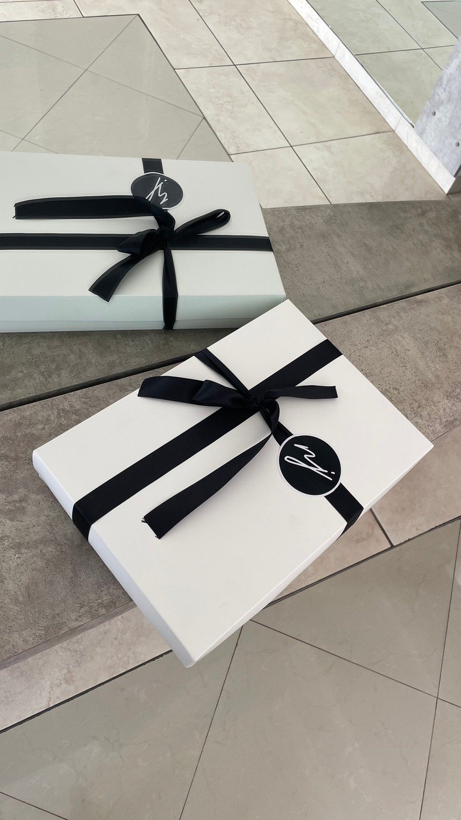 Presentación de regalo NJ Ink con cajas blancas y cintas negras
